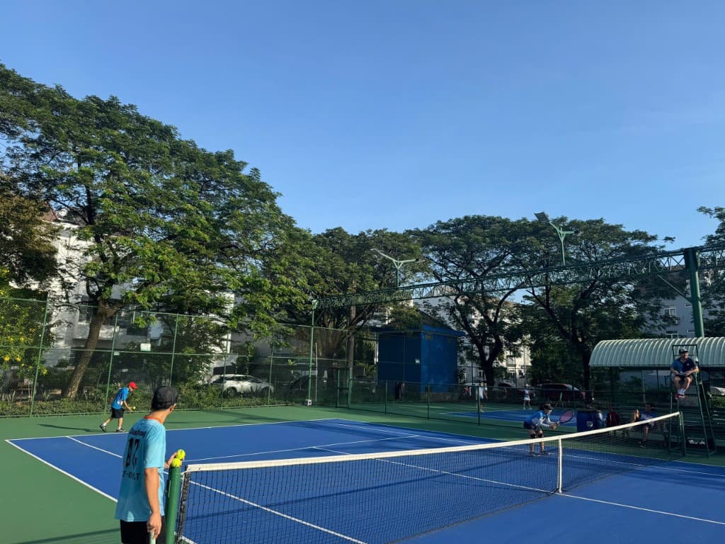 Vận động viên cầm bóng tennis bên lưới